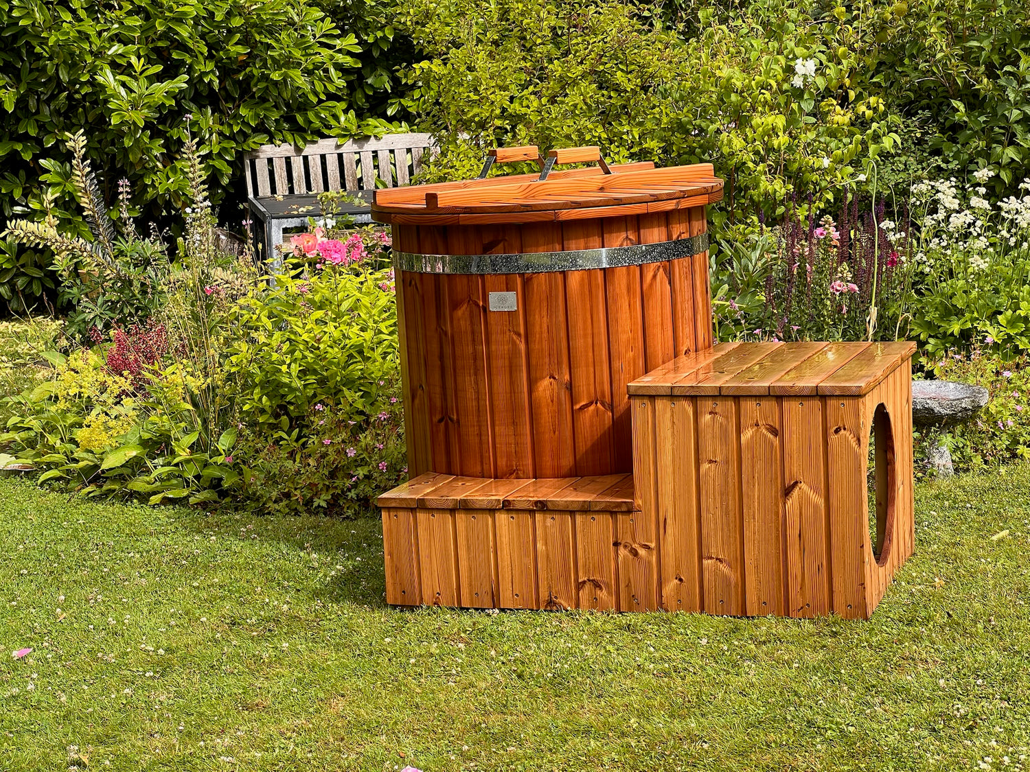 Isbad i træ med låg og trappe, placeret i en have