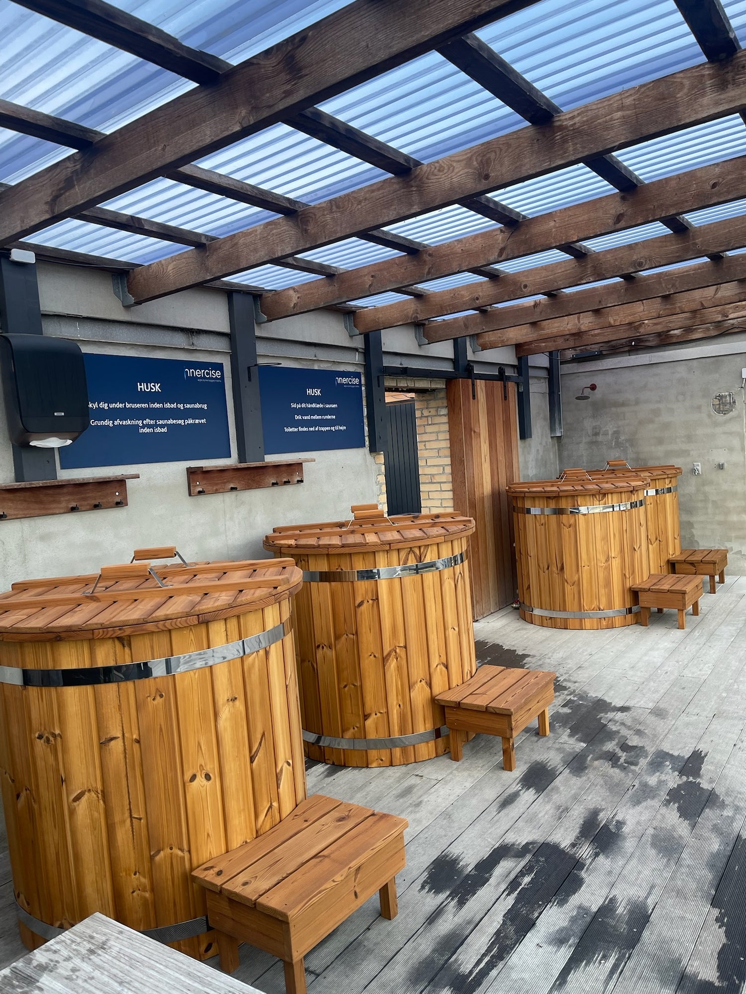 Tre iceKore isbade i træ med stålbånd og træskamler på terrassen.