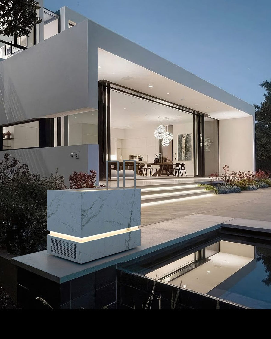 THOR isbad i hvid marmor ved en pool foran en moderne villa i skumringen